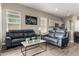 Cozy living room featuring tile floors, comfortable seating, and a neutral color scheme at 40918 W Hillman Dr, Maricopa, AZ 85138