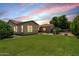 Backyard features a spacious lawn, outdoor seating under a pergola, and a built-in grill at 4318 N 180Th Dr, Goodyear, AZ 85395