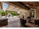 An outdoor covered patio area with stone fireplace, grill, and seating, perfect for entertaining at 4318 N 180Th Dr, Goodyear, AZ 85395