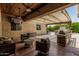 Covered patio with ceiling fans and a view of the outdoor kitchen and stone fireplace at 4318 N 180Th Dr, Goodyear, AZ 85395