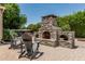 A stone outdoor fireplace, hot tub, and seating create the perfect outdoor space at 4318 N 180Th Dr, Goodyear, AZ 85395