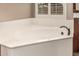Luxurious bathroom features a soaking tub, tiled floors, and wood cabinets at 4318 N 180Th Dr, Goodyear, AZ 85395