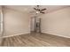 Spacious bedroom with wood floors, a ceiling fan, plantation shutters, and a glass paneled door at 4318 N 180Th Dr, Goodyear, AZ 85395