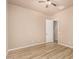 Bedroom with wood-look floors, ceiling fan, and access to an attached room at 4318 N 180Th Dr, Goodyear, AZ 85395