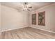 Bright bedroom featuring wood-look floors, ceiling fan, and shuttered windows at 4318 N 180Th Dr, Goodyear, AZ 85395