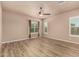 Spacious bedroom with wood floors, a ceiling fan, plantation shutters and decorative curtains at 4318 N 180Th Dr, Goodyear, AZ 85395