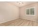 Cozy bedroom featuring wood-look floors, ceiling fan, and plantation shutter windows at 4318 N 180Th Dr, Goodyear, AZ 85395