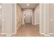 Open hallway with neutral paint, tile floors, and brick accent wall, providing a stylish transition space at 4318 N 180Th Dr, Goodyear, AZ 85395