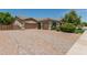 View of the exterior featuring a three-car garage and brick driveway with beautifully maintained front yard at 4318 N 180Th Dr, Goodyear, AZ 85395