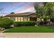 Well-maintained front yard with lush green lawn, manicured hedges, and mature tree at 4318 N 180Th Dr, Goodyear, AZ 85395