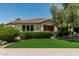 Charming home featuring neat landscaping, green grass, trimmed hedges and a decorative tree in the front yard at 4318 N 180Th Dr, Goodyear, AZ 85395