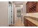 Hallway with tile floors and access to the living room, featuring granite counters with cherry-wood cabinets at 4318 N 180Th Dr, Goodyear, AZ 85395