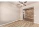 Versatile living space with laminate flooring and brick accent wall, suitable for various uses at 4318 N 180Th Dr, Goodyear, AZ 85395