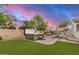 Backyard featuring a hot tub, pool, desert landscaping, hardscape, and artificial grass at 4453 S Huachuca Way, Chandler, AZ 85249