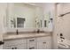 Bright bathroom featuring dual mirrors, granite countertop, dual sinks, white cabinetry, and tiled shower/tub at 4453 S Huachuca Way, Chandler, AZ 85249