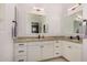 Bright bathroom featuring dual mirrors, granite countertop, dual sinks, and white cabinetry at 4453 S Huachuca Way, Chandler, AZ 85249