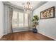 Dining room with neutral walls, hardwood floors, large windows with curtains, and a chandelier at 4453 S Huachuca Way, Chandler, AZ 85249