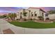 Beautiful Santa Fe-style home showcasing manicured landscaping, arched windows, and tile roof at 4453 S Huachuca Way, Chandler, AZ 85249