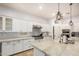 Bright kitchen with white cabinetry, stainless steel appliances, granite countertops, and chandelier lighting at 4453 S Huachuca Way, Chandler, AZ 85249