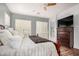 Serene primary bedroom with a dark wood dresser and hardwood floors, plantation shutters, and ceiling fan at 4453 S Huachuca Way, Chandler, AZ 85249