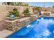 Beautiful pool area featuring rock waterfall features and lush landscaping in a private backyard setting at 4453 S Huachuca Way, Chandler, AZ 85249