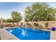 Backyard pool with waterfall features, lounge chairs, and mature landscaping at 4453 S Huachuca Way, Chandler, AZ 85249