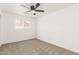 Bright bedroom with neutral carpet, ceiling fan, and a window letting in natural light at 4613 N 53Rd Dr, Phoenix, AZ 85031