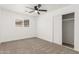 Bedroom features neutral carpet, ceiling fan, window, and a closet with sliding doors at 4613 N 53Rd Dr, Phoenix, AZ 85031