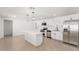 Bright kitchen features white cabinets, stainless steel appliances, and an island with bar seating at 4613 N 53Rd Dr, Phoenix, AZ 85031