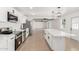Modern kitchen with stainless steel appliances, white cabinetry, and a large center island at 4613 N 53Rd Dr, Phoenix, AZ 85031