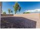 Large gravel backyard surrounded by a beige block wall offers easy maintenance at 513 S 115Th Dr, Avondale, AZ 85323