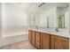 Bathroom featuring a double sink vanity, a large mirror, and a shower/bath at 513 S 115Th Dr, Avondale, AZ 85323
