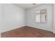 Spacious bedroom with neutral walls, dark wood floors, and a window at 513 S 115Th Dr, Avondale, AZ 85323