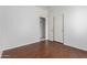 A spacious bedroom with wood-look floors, closet, and an open doorway at 513 S 115Th Dr, Avondale, AZ 85323