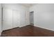 Bedroom featuring hardwood floors, white walls, and a closet with sliding doors at 513 S 115Th Dr, Avondale, AZ 85323