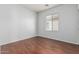 Bright bedroom with neutral walls, window with blinds, and hardwood flooring at 513 S 115Th Dr, Avondale, AZ 85323