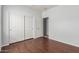 Bedroom with hardwood floors, white closet doors, and a double door entrance at 513 S 115Th Dr, Avondale, AZ 85323