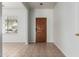Bright entryway with a wood front door, neutral tile flooring, and a window providing natural light at 513 S 115Th Dr, Avondale, AZ 85323