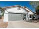 Charming single-story home featuring a gray two-car garage and a well-maintained front yard at 513 S 115Th Dr, Avondale, AZ 85323