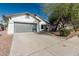 Charming single-story home featuring a gray two-car garage and a well-maintained front yard with mature landscaping at 513 S 115Th Dr, Avondale, AZ 85323