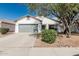 Charming single-story home featuring a gray two-car garage and a well-maintained front yard with mature landscaping at 513 S 115Th Dr, Avondale, AZ 85323