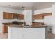 Kitchen island with sink, granite countertops, and oak cabinets, complemented by stainless steel appliances at 513 S 115Th Dr, Avondale, AZ 85323