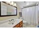 Well-lit bathroom featuring a single sink vanity and shower with curtain at 5144 W Sweetwater Ave, Glendale, AZ 85304