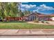 Charming single-story home featuring a well-manicured lawn and mature trees at 5144 W Sweetwater Ave, Glendale, AZ 85304