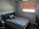 Cozy bedroom with plaid bedding and natural light from the window at 5539 N 31St Ln, Phoenix, AZ 85017