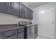 Laundry room featuring gray cabinetry, countertop and modern washer/dryer at 6449 E Paradise Ln, Scottsdale, AZ 85254