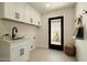 Well-lit laundry room boasts custom cabinets and stylish patterned flooring at 7618 N Via Del Paraiso --, Scottsdale, AZ 85258