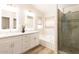 Elegant bathroom featuring dual sinks, modern lighting, a soaking tub, and glass-enclosed shower at 8343 W Audrey Ln, Peoria, AZ 85382