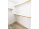 Walk-in closet with wood laminate flooring and wooden shelving units at 8343 W Audrey Ln, Peoria, AZ 85382