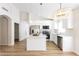 Bright, open kitchen with stainless steel appliances, white cabinets, island, and stylish pendant lighting at 8343 W Audrey Ln, Peoria, AZ 85382